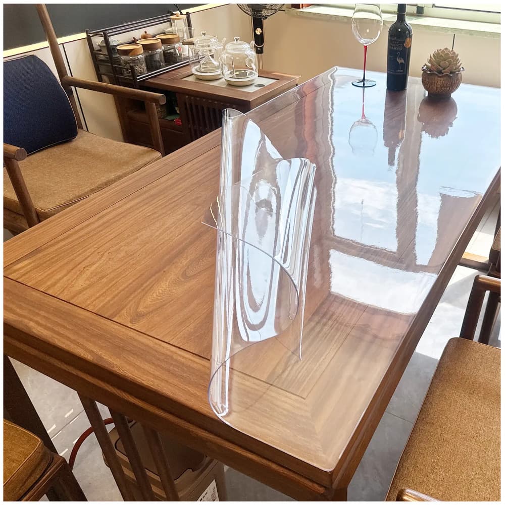 Clear PVC table protector fitted on a dining table; exact size is stated in the listing